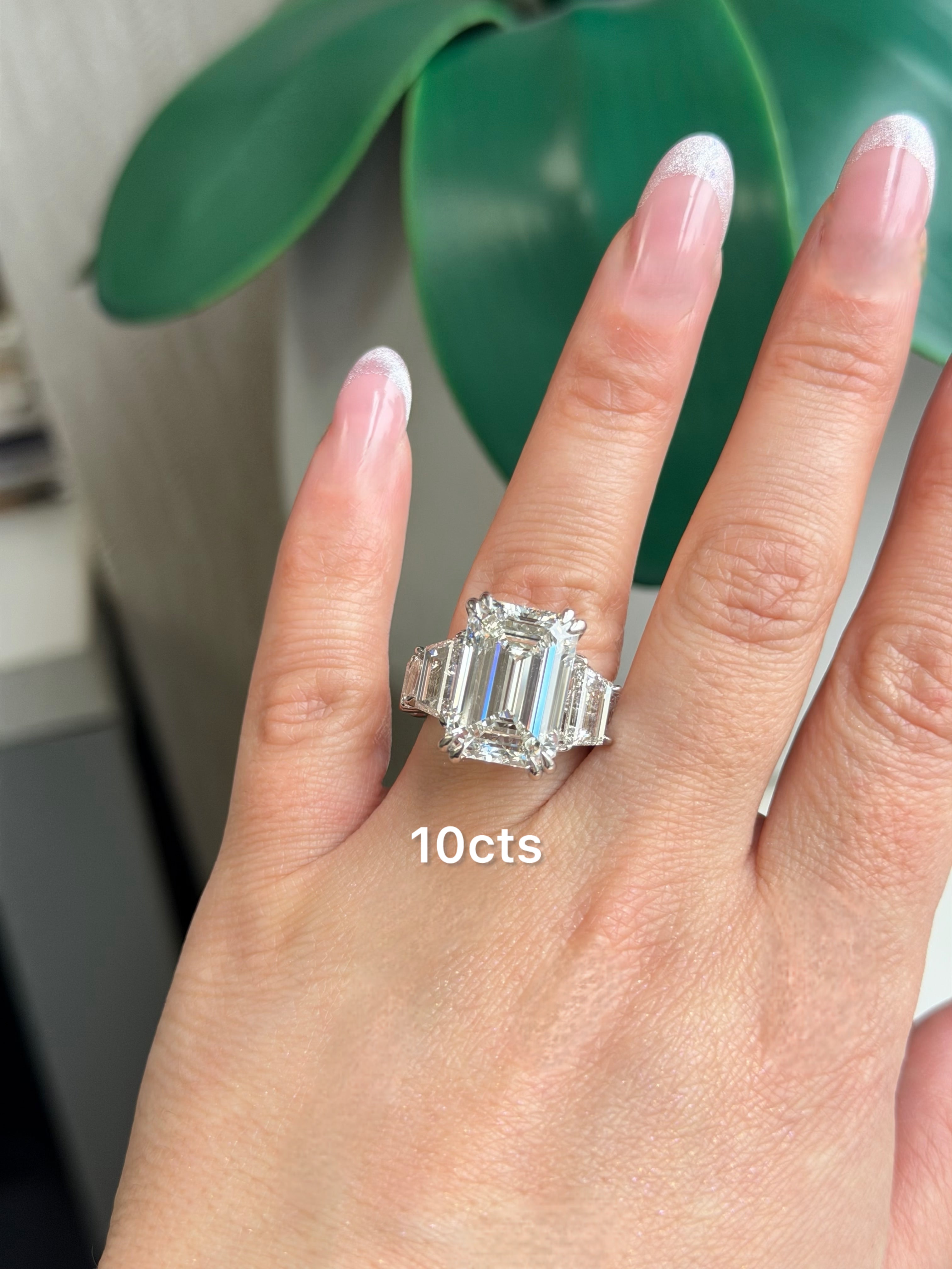 Emerald cut diamond ring worn on hand showing scale and proportion