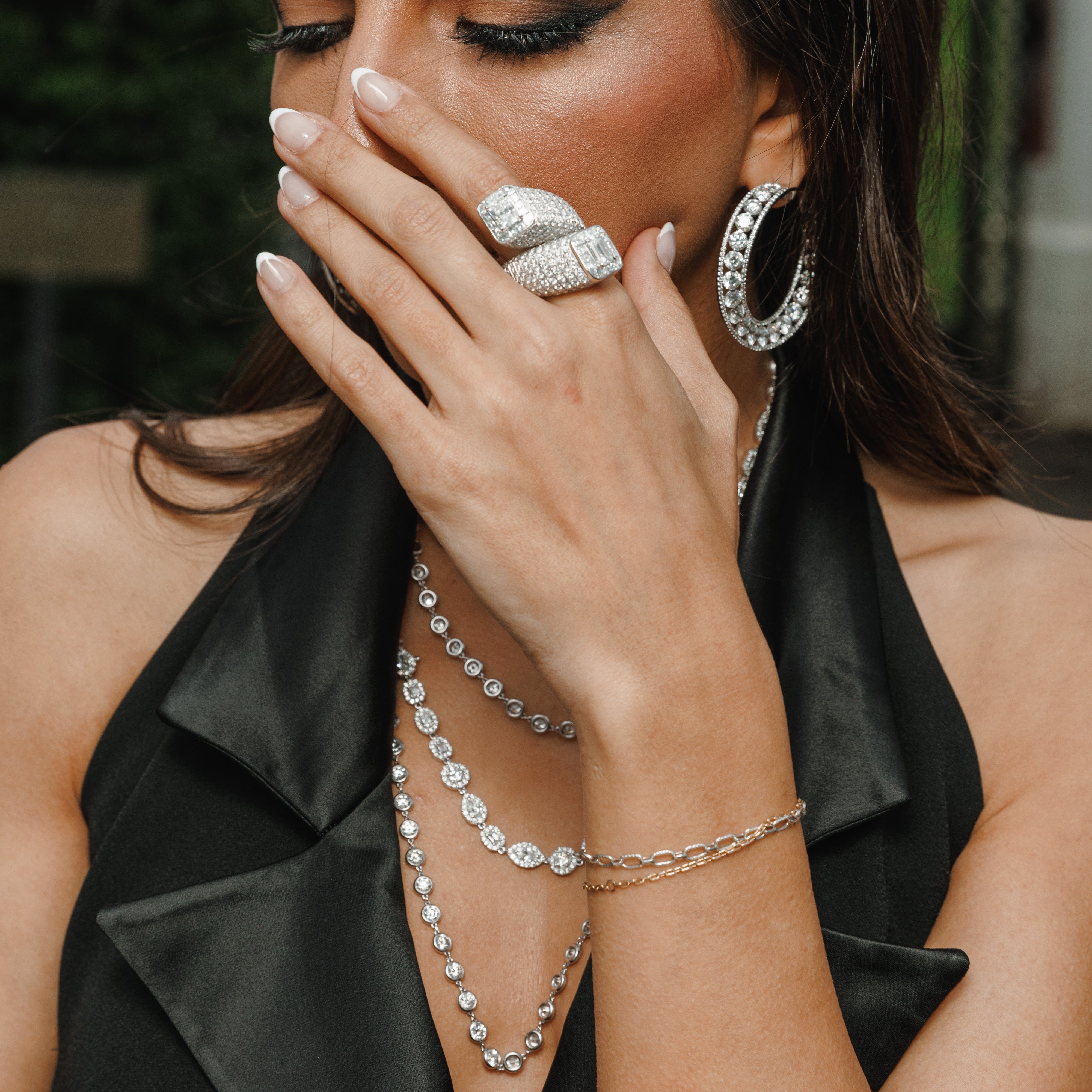 Woman wearing elegant jewelry including a ring, earrings, and necklaces.