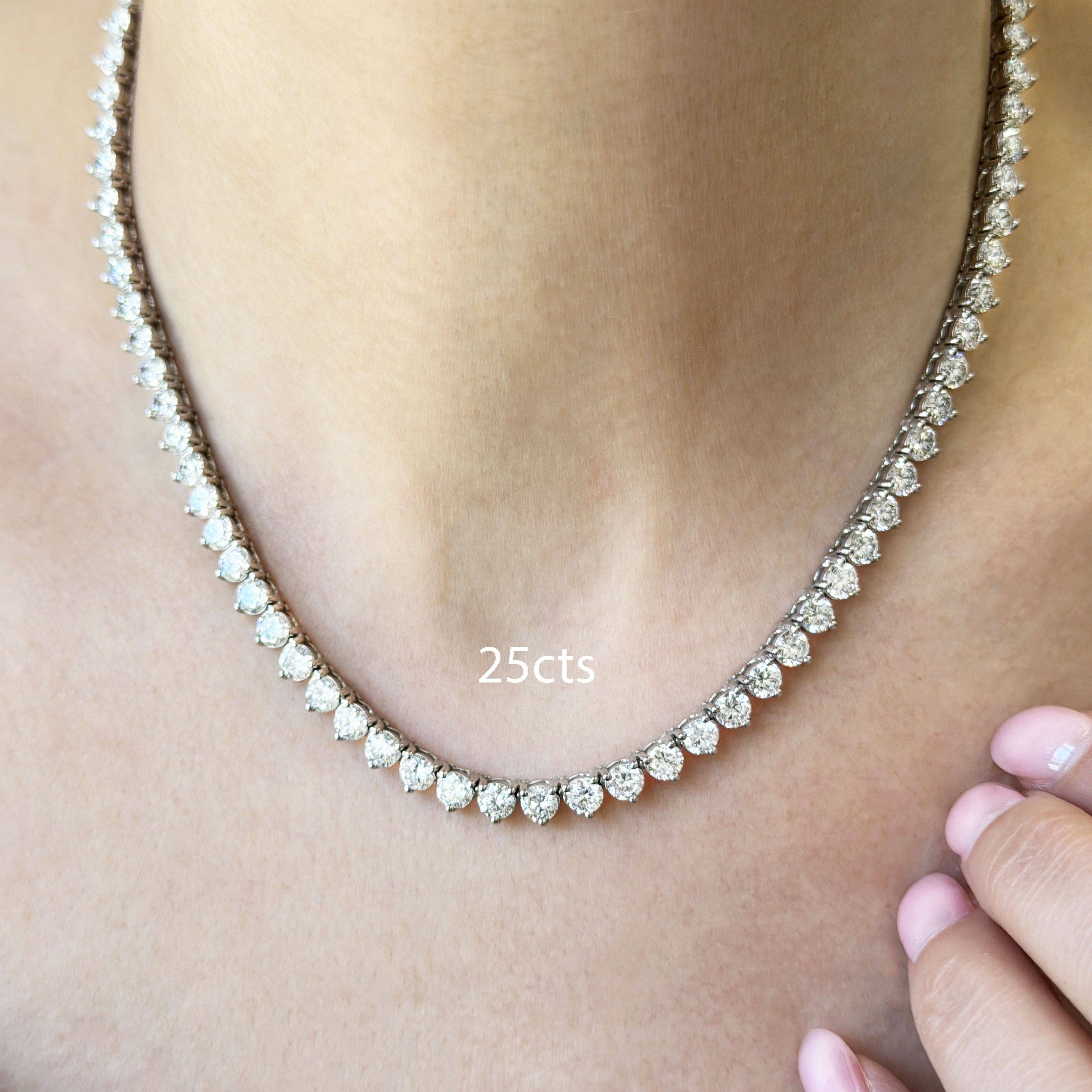 Diamond necklace on a person's neck with '25cts' label