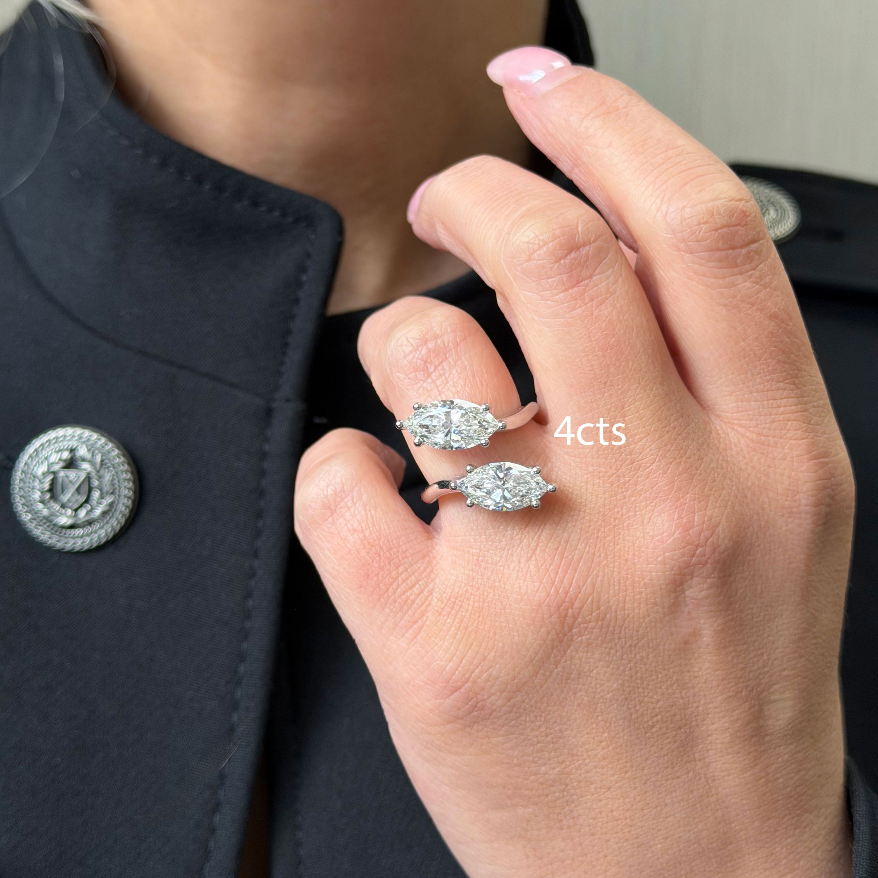 Hand wearing two diamond rings with a blurred background