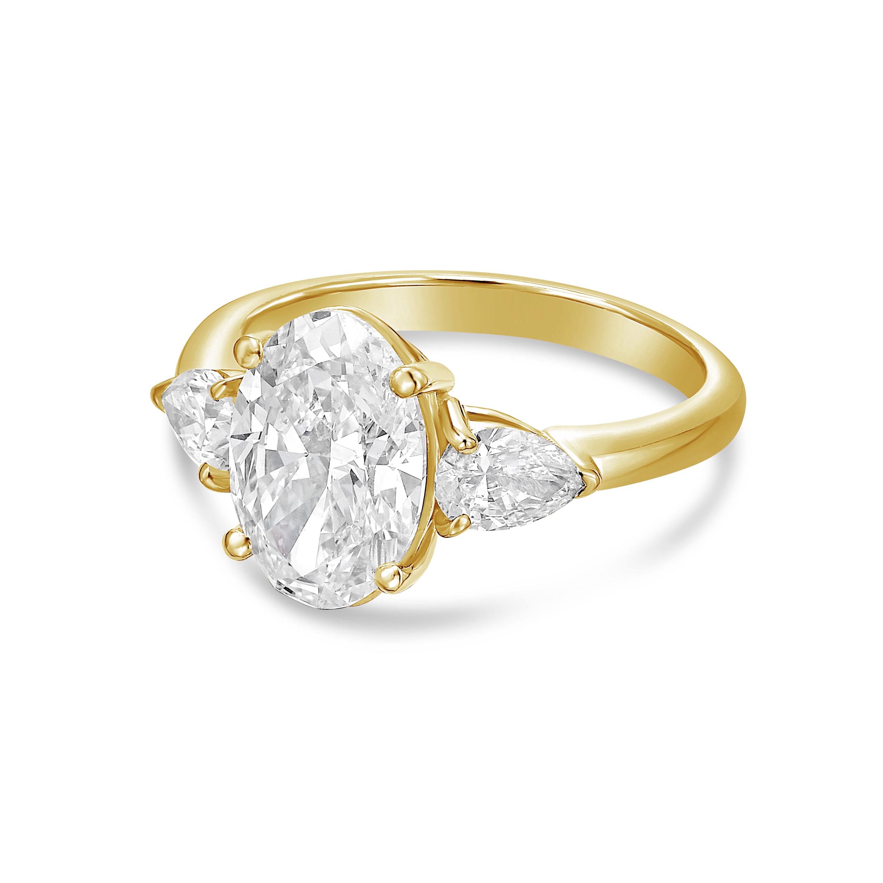 Lab-grown oval and pear three-stone engagement ring in 18kt yellow gold, angled view
