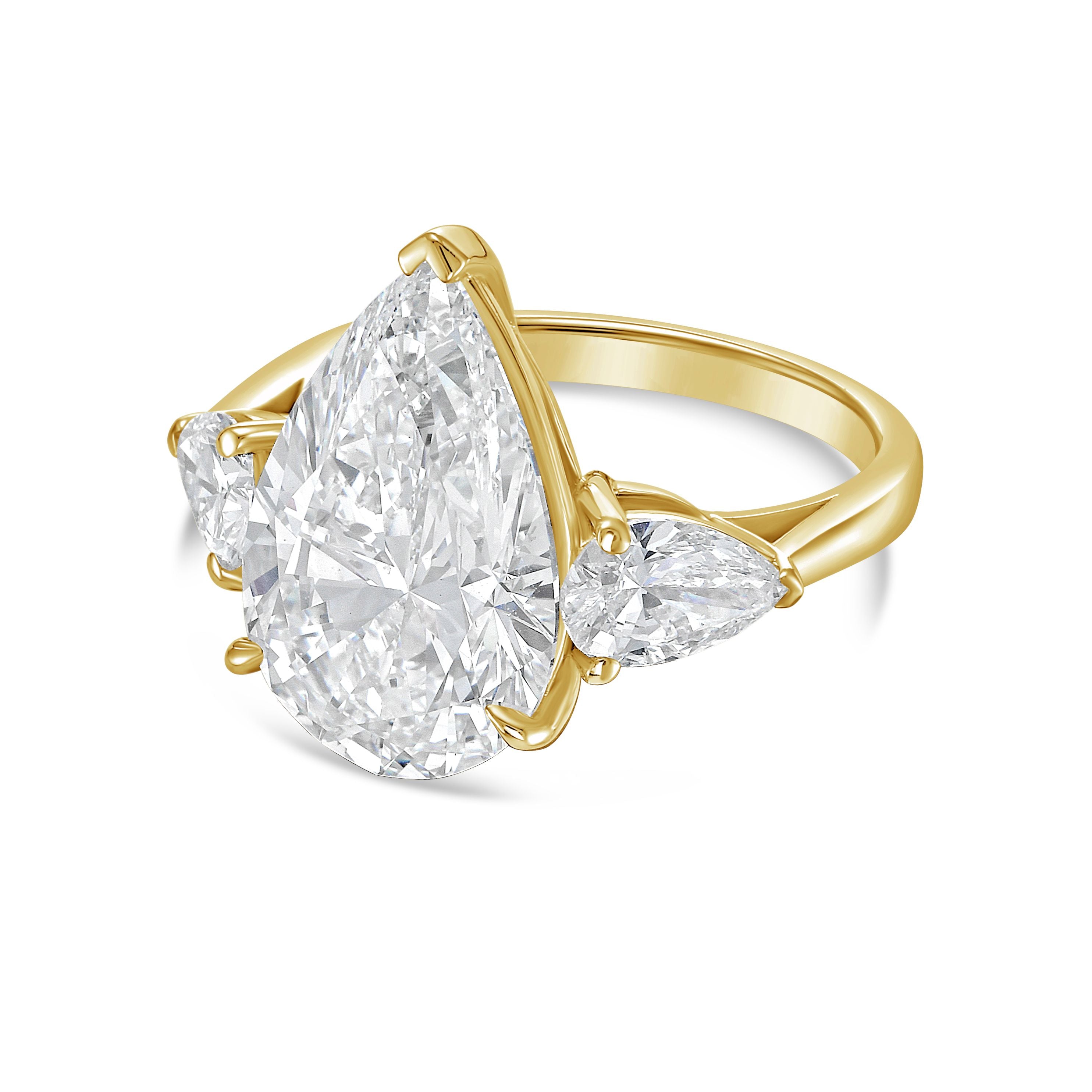 Gold ring with a pear-shaped diamond on a white background
