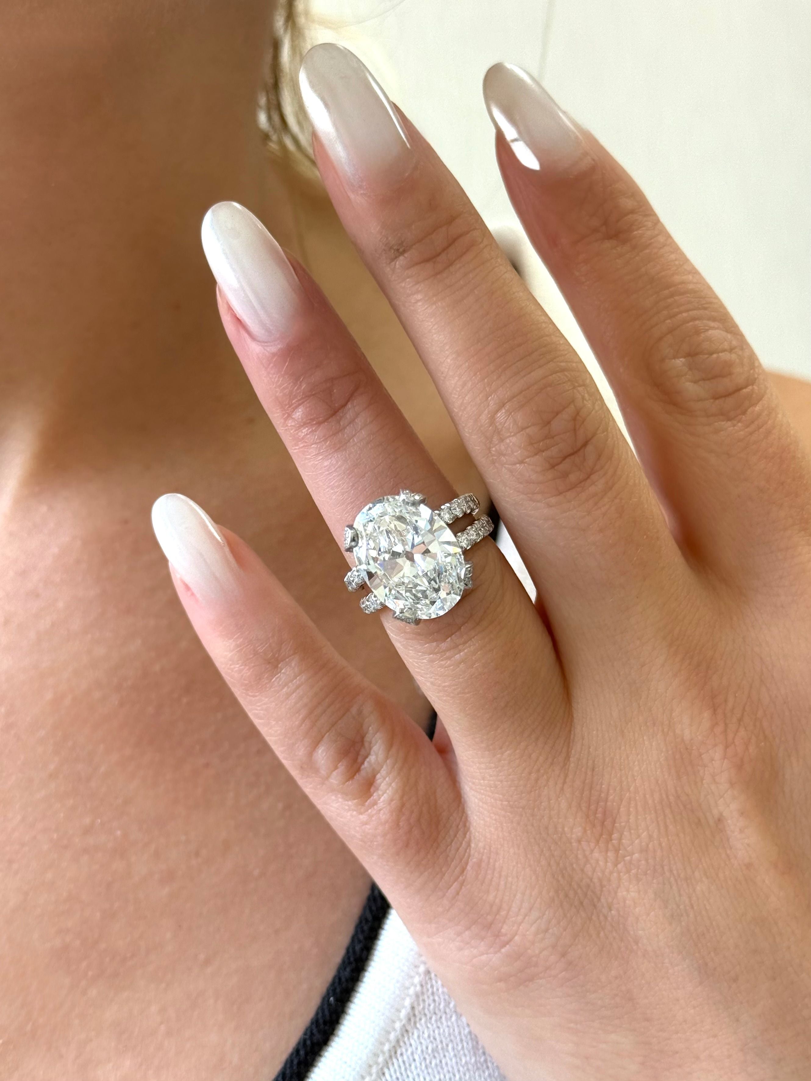 Platinum oval-cut diamond engagement ring with pavé split shank and bold bridal sparkle