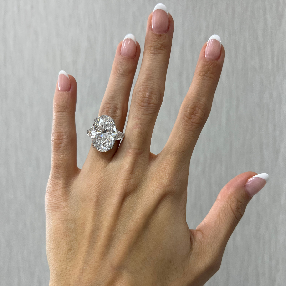 Three-stone oval diamond ring with heart-shaped side stones, 7.01 carats