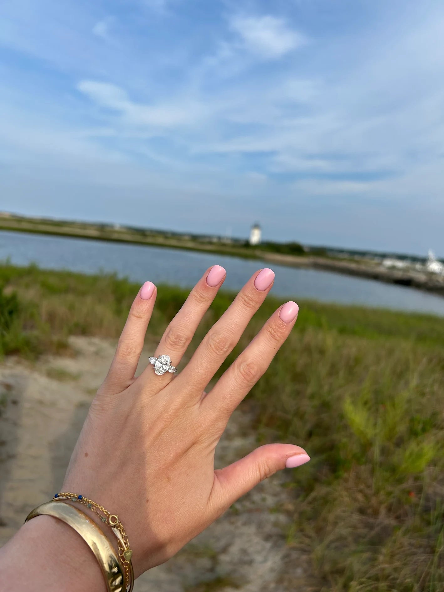 Customer photo: close-up of oval and pear three-stone engagement ring in 18kt white gold