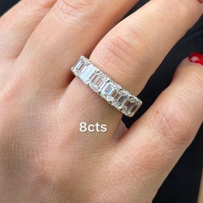 Emerald cut 8cts diamond eternity band styled on hand with neutral background