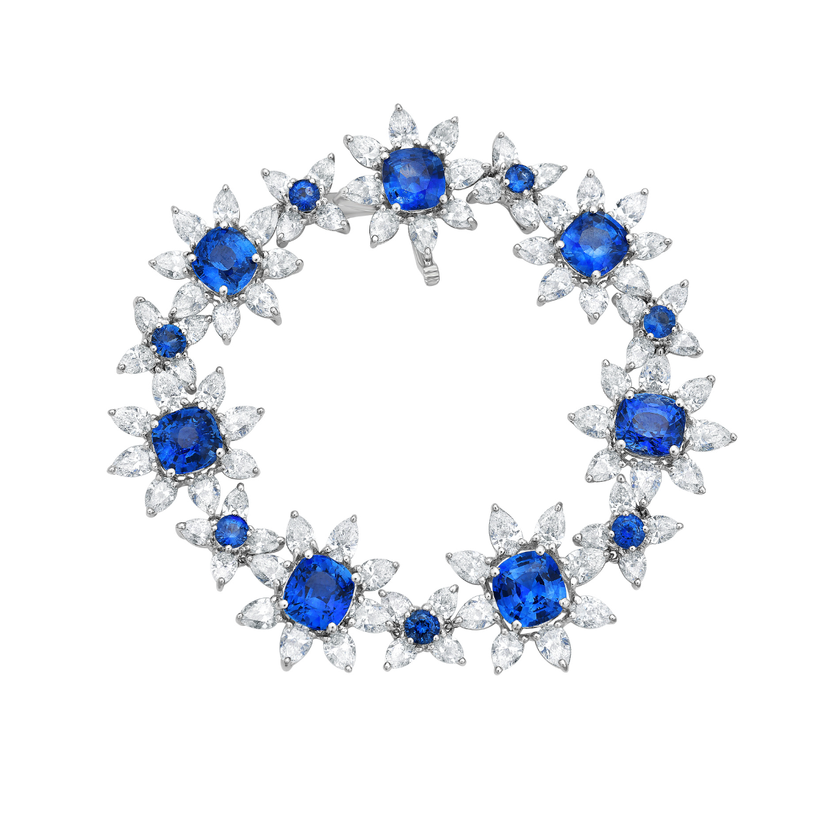 A platinum bracelet featuring cushion cut sapphires and pear shaped diamonds, arranged in a flower pattern.