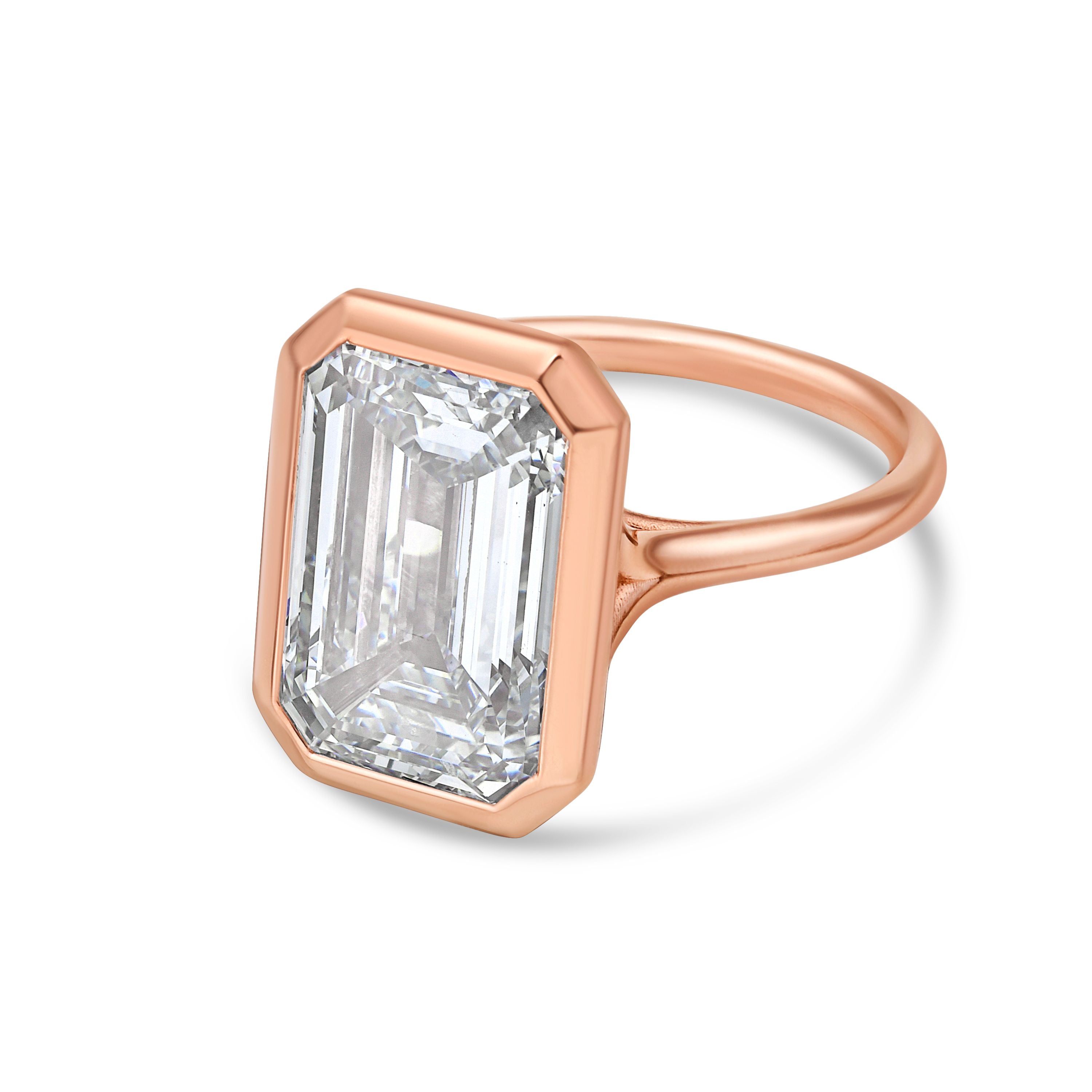 Rose gold ring with a large emerald-cut diamond on a white background