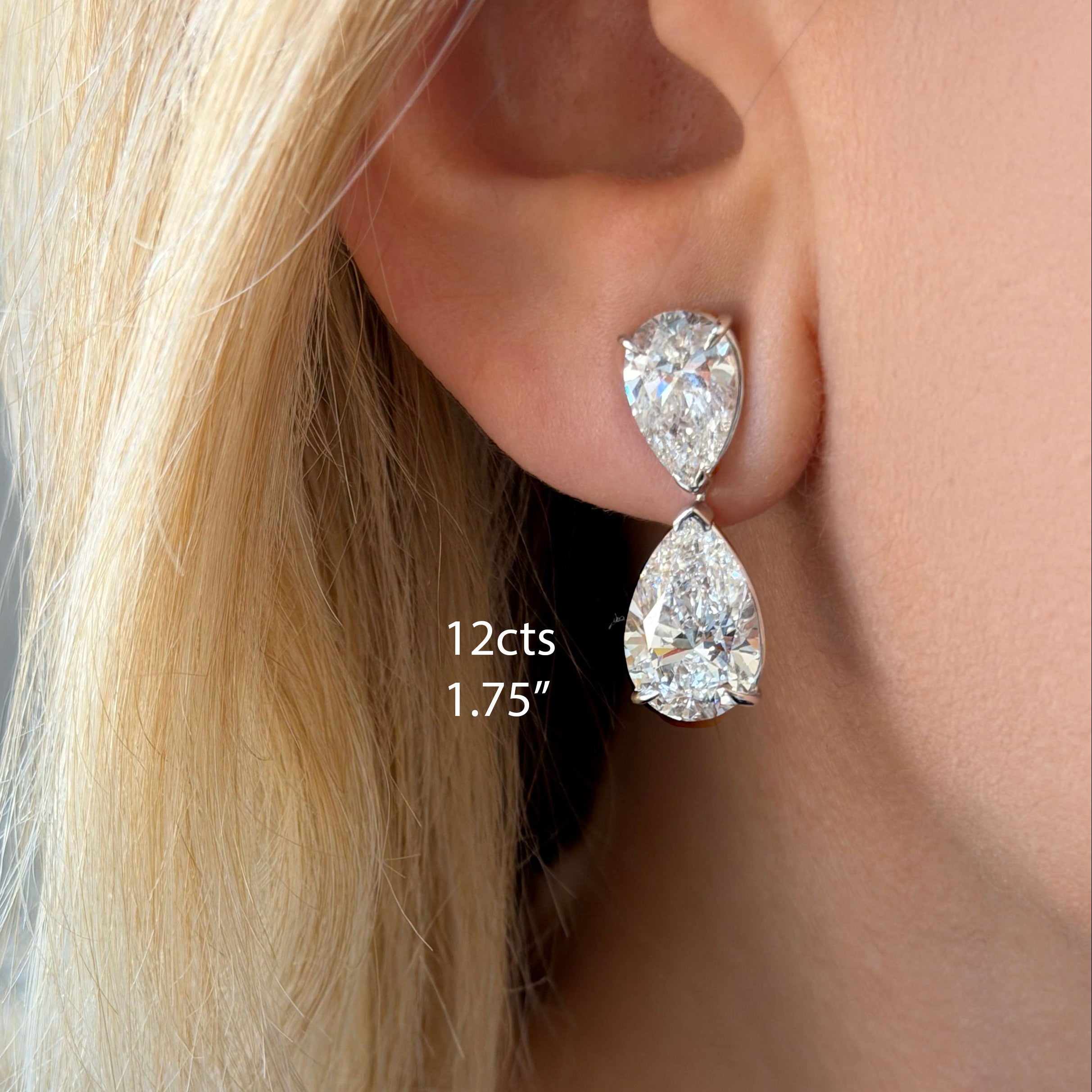 Lab-grown pear diamond drop earrings shown on ear in 12ct total weight on blonde model