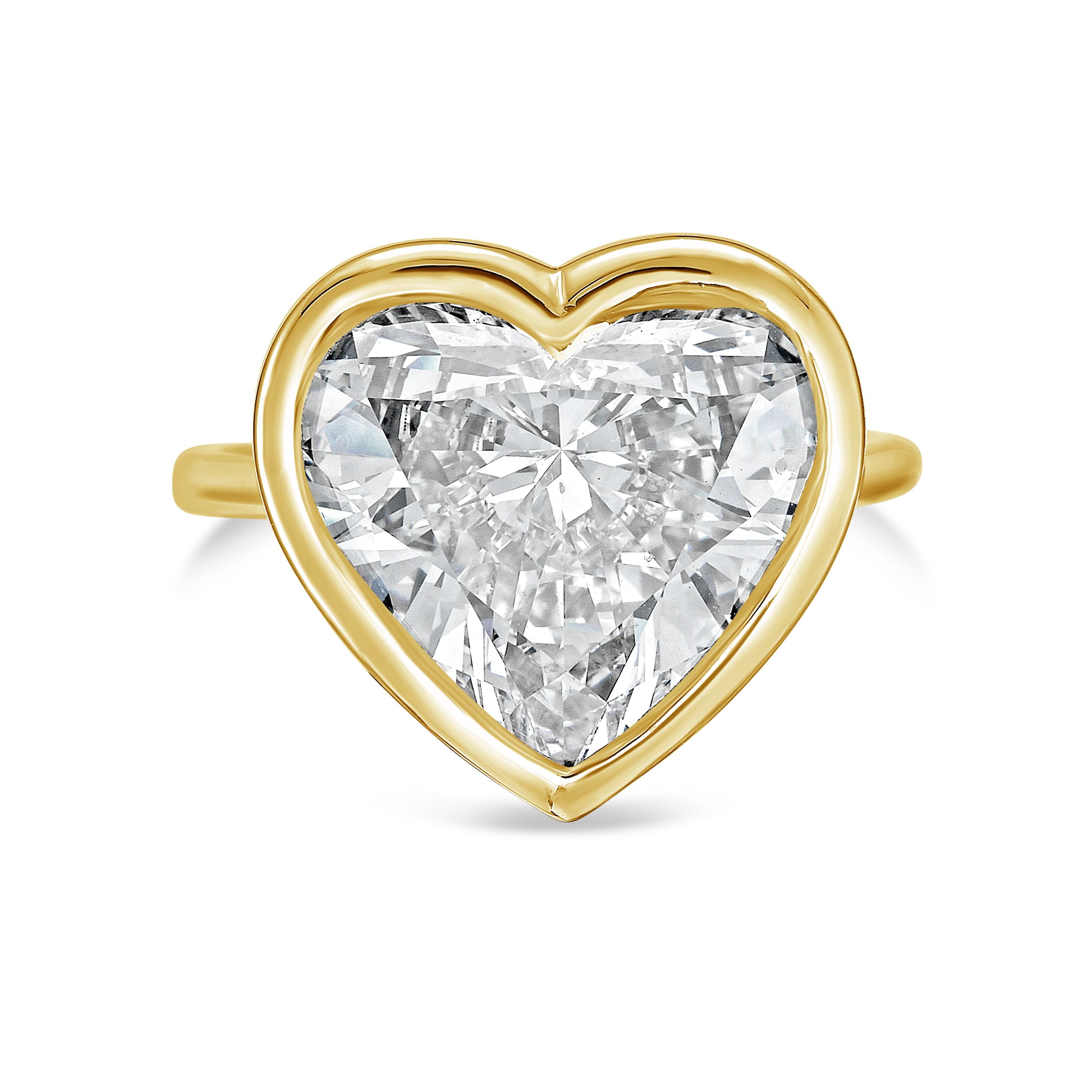 Heart-shaped diamond ring with gold setting on a white background