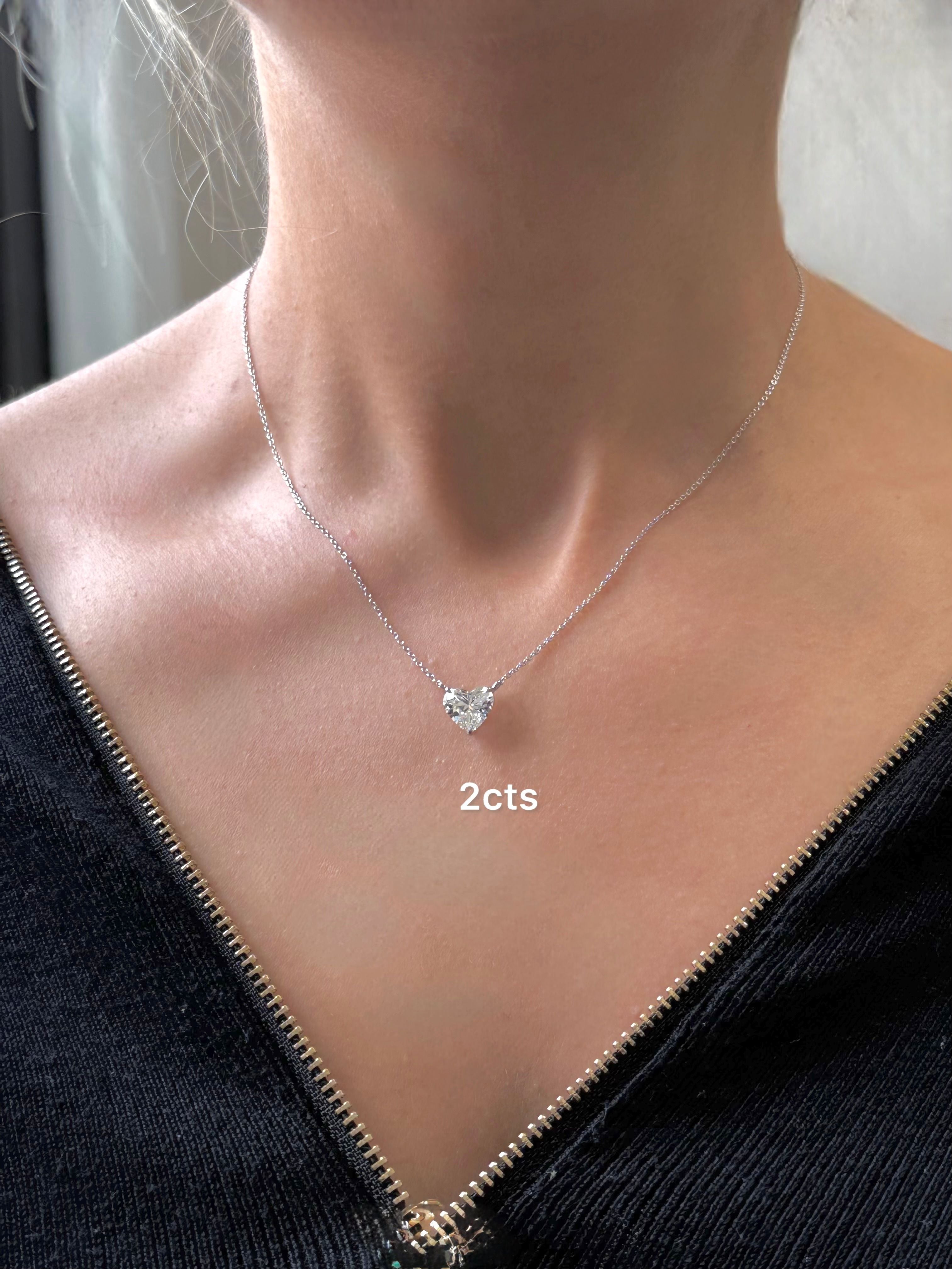Necklace with a diamond pendant on a person wearing a black top.