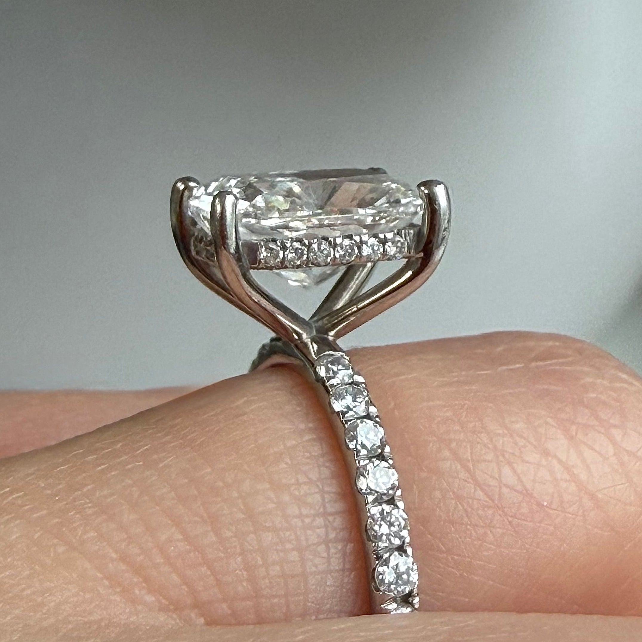 Diamond ring on a finger with a neutral background