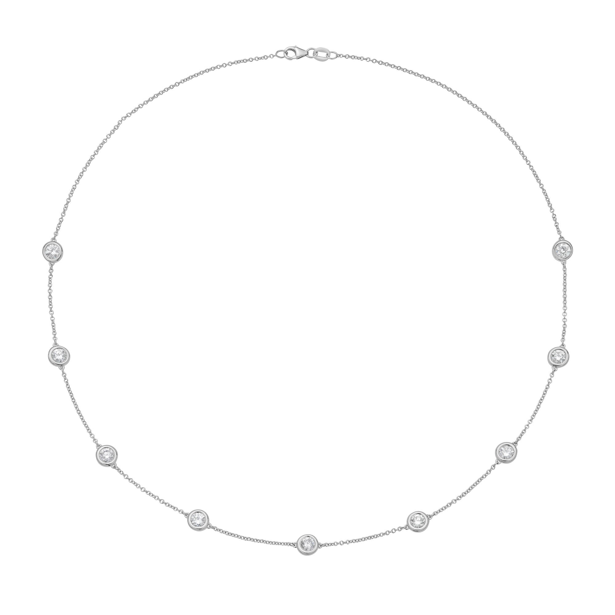 A delicate  chain necklace with seven small, bezel-set round clear gemstones spaced evenly around the circle, displayed on a solid white background.