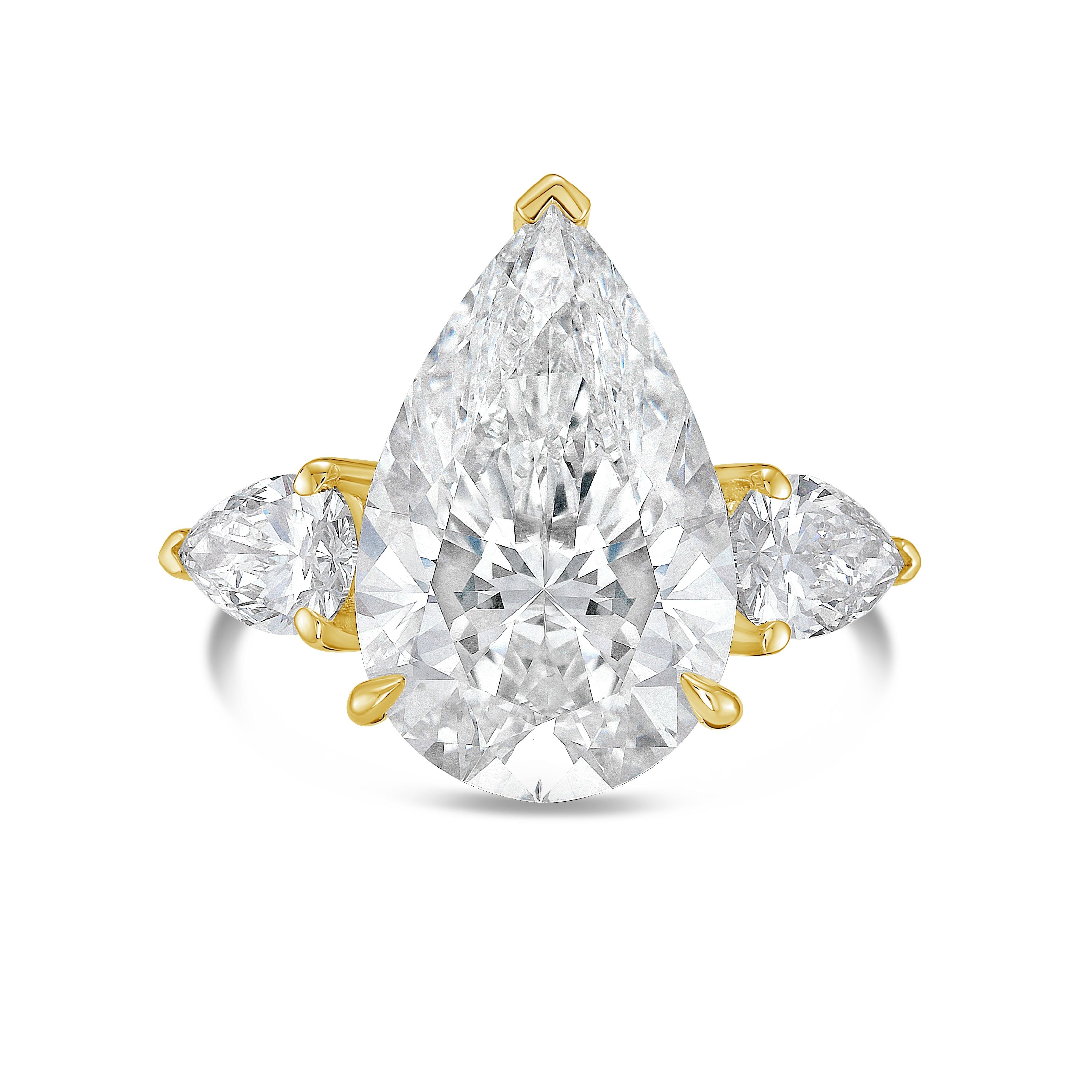 Diamond ring with pear-shaped center stone and smaller stones on a white background
