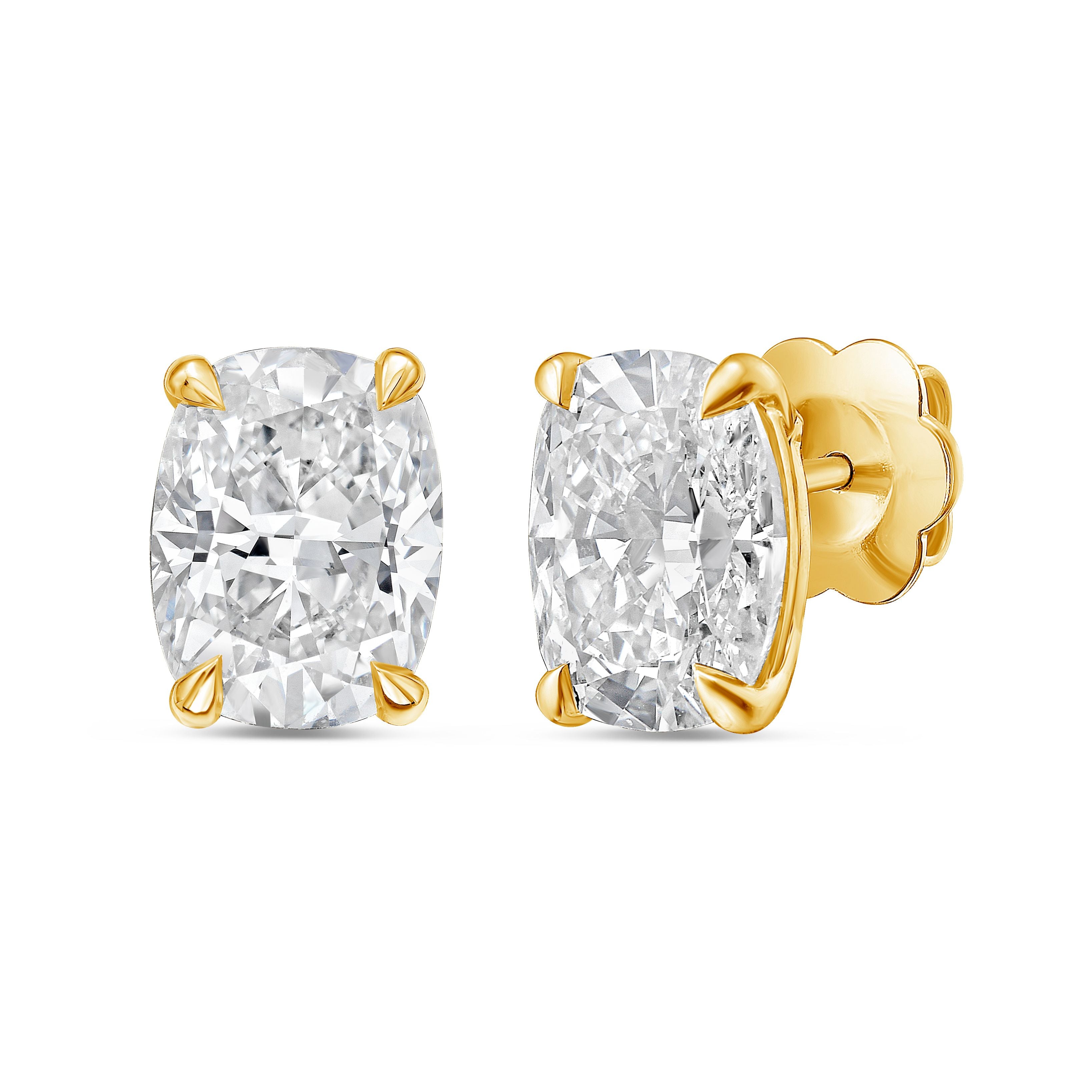 Gold earrings with large clear gemstones on a white background