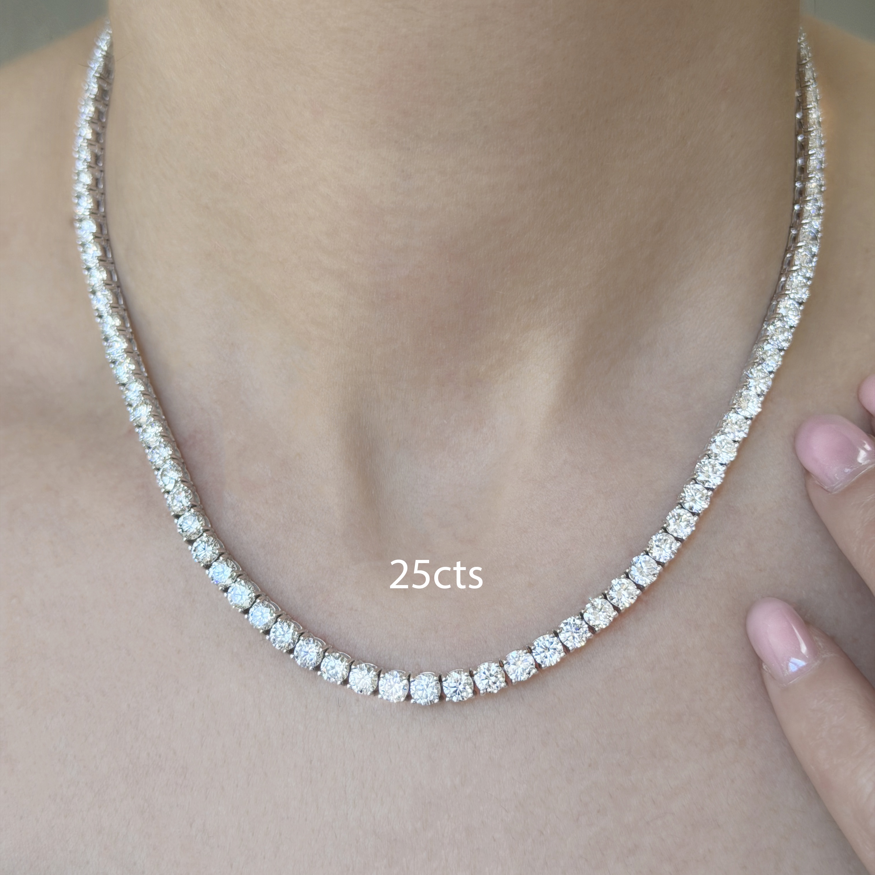 Diamond necklace being worn on a person's neck with a neutral background