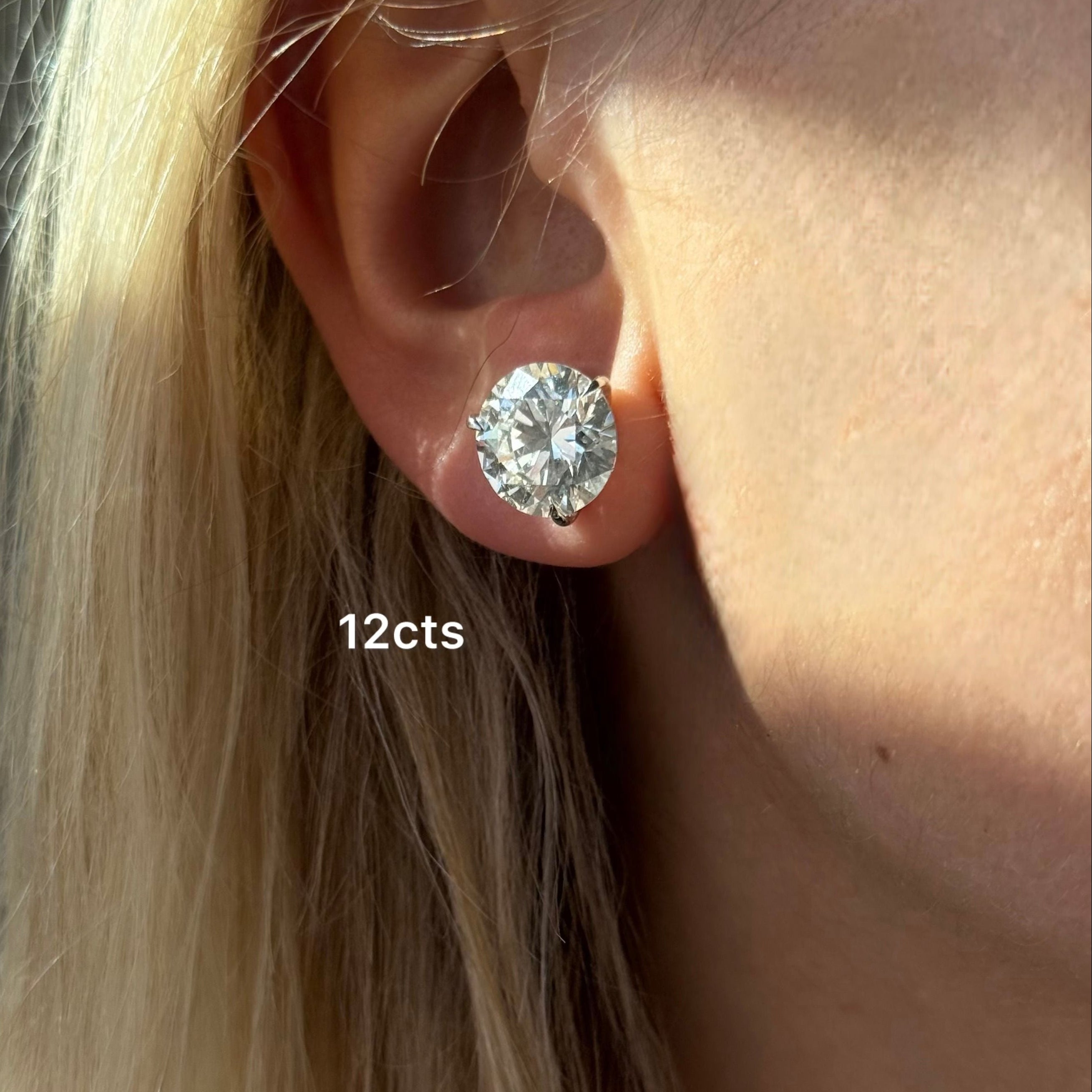 Close-up of an ear wearing a diamond earring with '12cts' text.