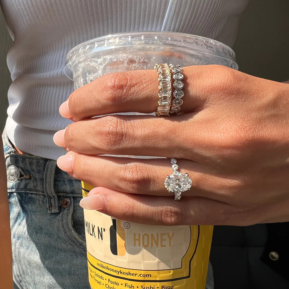 Emerald cut diamond eternity band worn on hand showing scale and proportion