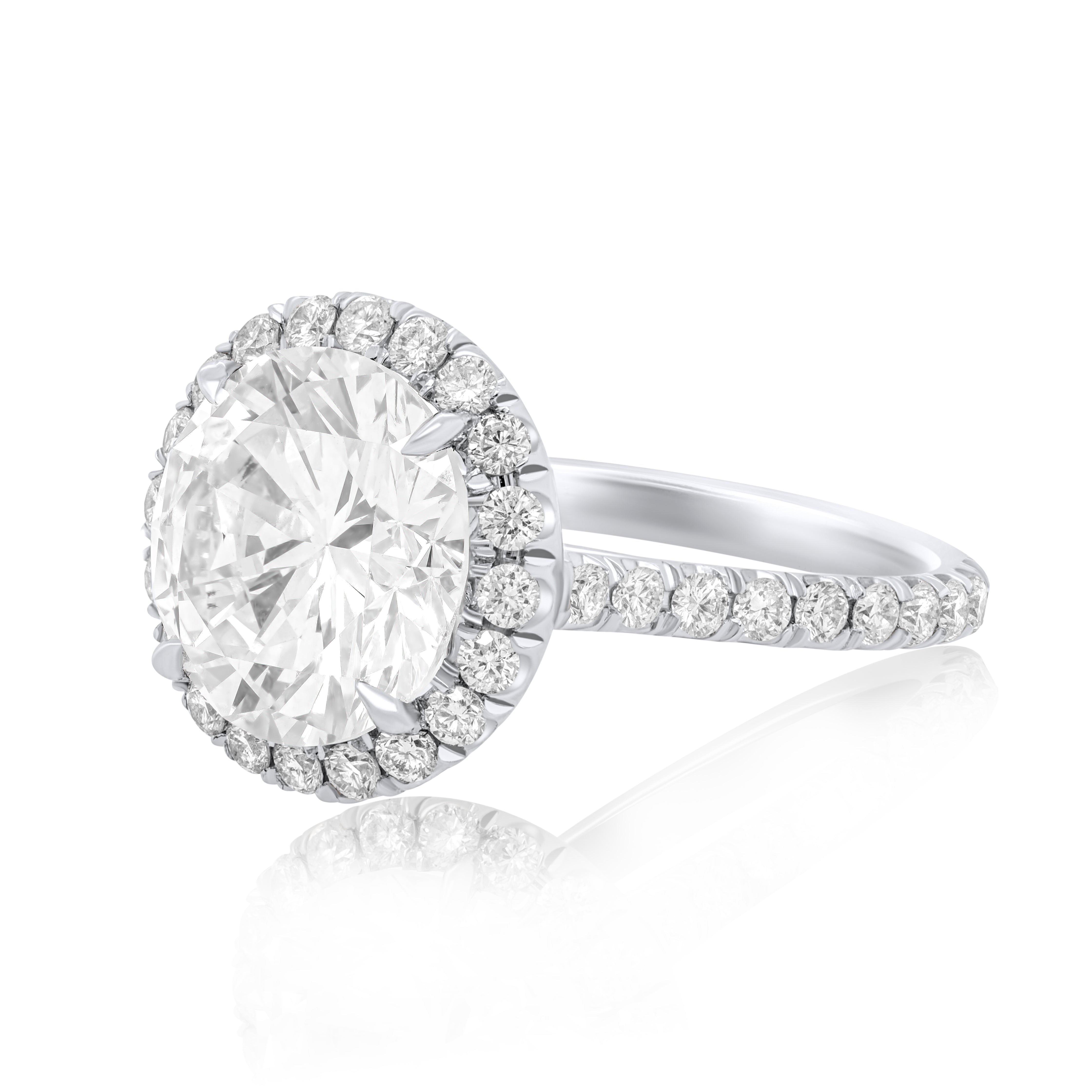 Side profile of round diamond halo engagement ring showing band height and prong setting